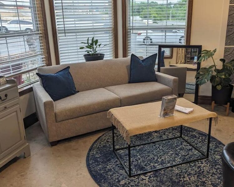 Cozy Lobby Seating at The Dutton Inn at The Dutton Inn | Branson Mo Comfortable beige sofa with blue pillows and a coffee table in The Dutton Inn lobby near at The Dutton Inn | Branson Mo