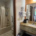 Bathroom and vanity area with granite countertop, towels, and hairdryer at The Dutton Inn in at The Dutton Inn | Branson Mo